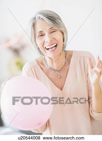 Stock Photo - Portrait of woman holding balloon. Fotosearch
