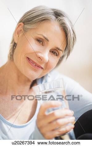 Picture - Portrait of woman holding glass of water. Fotosearch