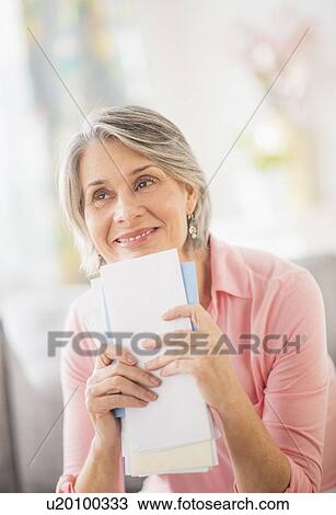 Stock Image - Portrait of woman holding mail. Fotosearch