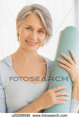 Portrait of woman holding yoga mat View Large Photo Image Stock Photography - Portrait of woman holding yoga mat. Fotosearch