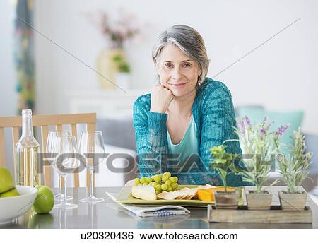 Portrait of woman leaning on kitchen counter View Large Photo Image Stock Photograph - Portrait of woman leaning on kitchen counter. Fotosearch