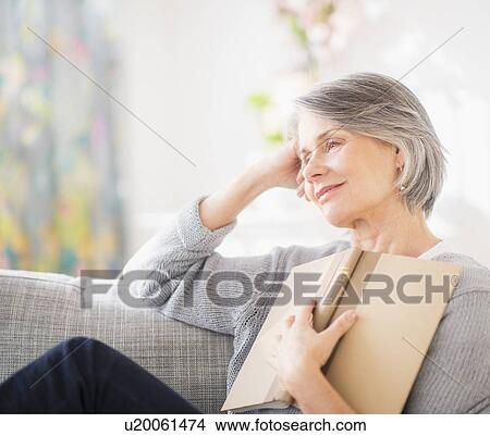 Picture - Portrait of woman relaxing on sofa. Fotosearch