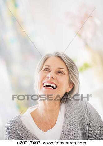 Stock Image - Portrait of woman relaxing on sofa. Fotosearch