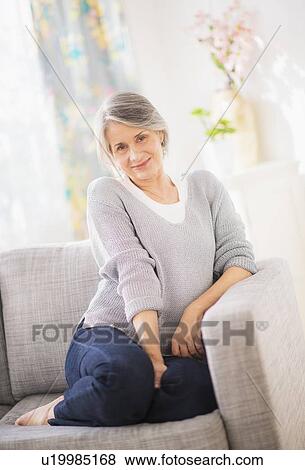 Stock Photo - Portrait of woman relaxing on sofa. Fotosearch