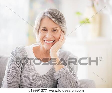 Stock Photo - Portrait of woman relaxing on sofa. Fotosearch
