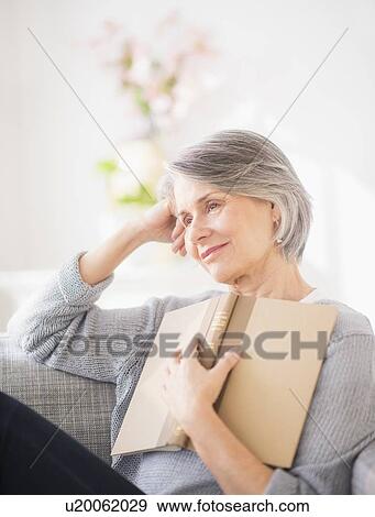 Stock Photo - Portrait of woman relaxing on sofa. Fotosearch
