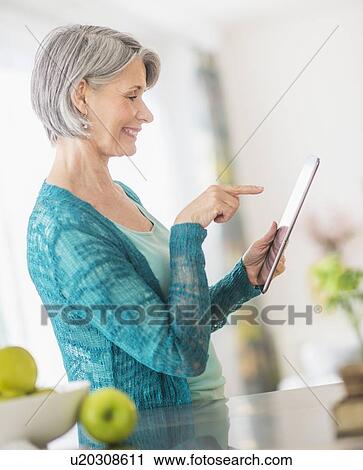 Stock Image - Portrait of woman using digital tablet. Fotosearch