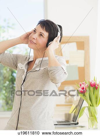 Stock Image - Portrait of woman using headphones. Fotosearch
