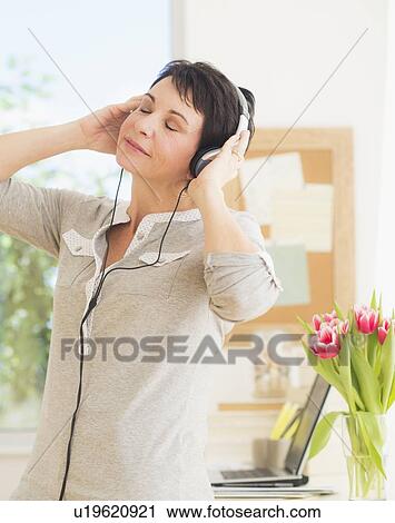 Portrait of woman using headphones View Large Photo Image Stock Image - Portrait of woman using headphones. Fotosearch