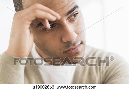 Portrait of young man holding head in hands View Large Photo Image Stock Image - Portrait of young man holding head in hands. Fotosearch