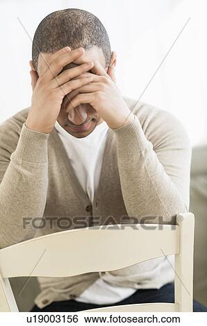 Portrait of young man holding head in hands View Large Photo Image Stock Photograph - Portrait of young man holding head in hands. Fotosearch