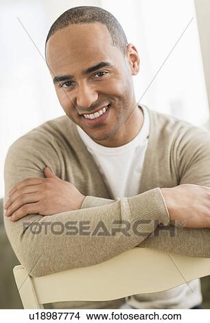 Portrait of young man sitting with arms crossed View Large Photo Image Picture - Portrait of young man sitting with arms crossed. Fotosearch