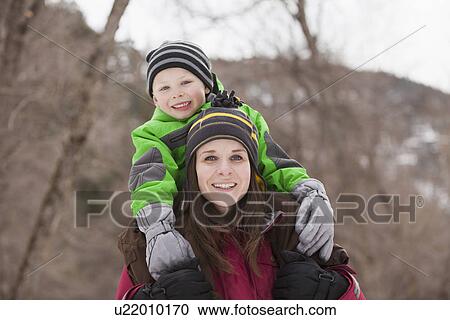 Portrait of young woman carrying boy (4-5) on shoulders View Large Photo Image Stock Image - Portrait of young woman carrying boy (4-5) on shoulders . Fotosearch