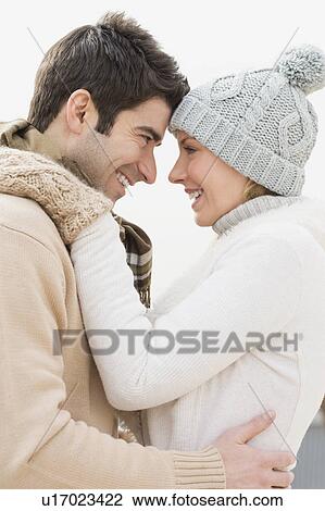 Stock Image - Profile of couple in winter clothing. Fotosearch