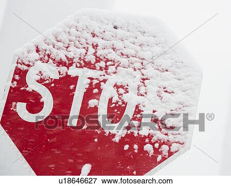 Stock Photo - Red stop sign covered with snow. Fotosearch