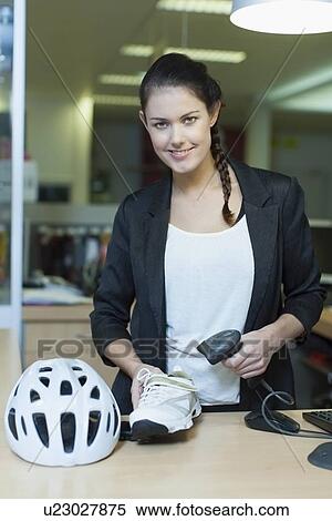 Stock Photography - Sales clerk selling cycling shoes and helmet. Fotosearch