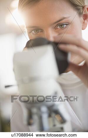 Picture - Scientist doing research on microscopes. Fotosearch