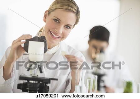 Scientists doing research on microscopes View Large Photo Image Stock Image - Scientists doing research on microscopes. Fotosearch