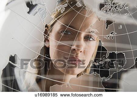 Studio portrait of woman peering through translucent world map View Large Photo Image Stock Photography - Studio portrait of woman peering through translucent world map. Fotosearch
