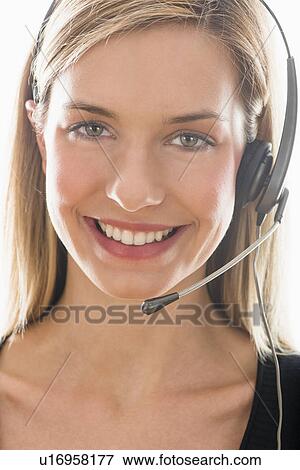 Stock Photo - Studio portrait of young woman wearing headset. Fotosearch