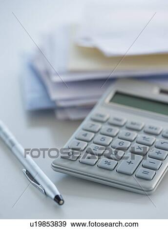 Stock Photo - Studio Shot of calculator, pen and paper material. Fotosearch