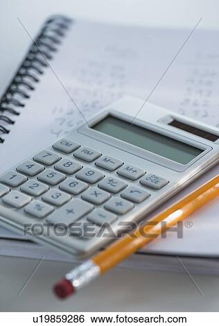 Studio Shot of calculator pen and spiral-bound notebook View Large Photo Image Stock Photograph - Studio Shot of calculator pen and spiral-bound notebook . Fotosearch