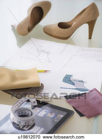 Stock Image - Studio Shot of digital tablet, tape measure, sketch and shoes. Fotosearch