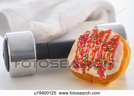 Studio Shot of jelly doughnut and hand weight View Large Photo Image Stock Photography - Studio Shot of jelly doughnut and hand weight. Fotosearch