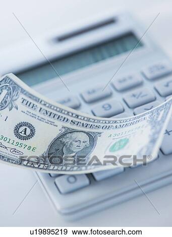 Stock Photo - Studio Shot of one dollar bill and calculator. Fotosearch