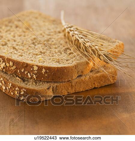 Stock Image - Studio Shot of slices of bread with wheat. Fotosearch