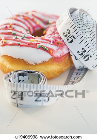 Studio Shot of tape measure wrapped around jelly doughnut View Large Photo Image Stock Photo - Studio Shot of tape measure wrapped around jelly doughnut. Fotosearch