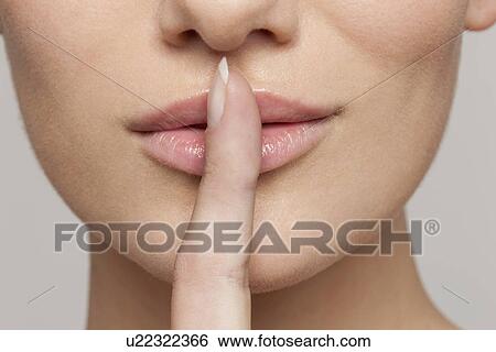 Studio shot portrait of young woman in white blouse with finger on lips View Large Photo Image Stock Photograph - Studio shot portrait of young woman in white blouse with finger on lips. Fotosearch