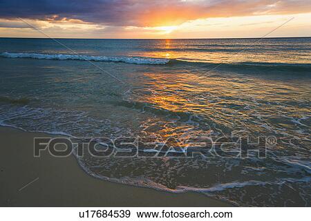 Stock Photo - Sun setting over sea. Fotosearch