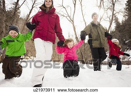 Stock Image - Three children (2-3, 4-5) with parents during stroll. Fotosearch