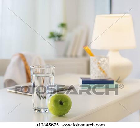 View of glass of water, apple and digital tablet on table View Large Photo Image Stock Photography - View of glass of water, apple and digital tablet on table. Fotosearch