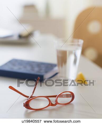 Stock Photo - View of spectacles, personal organizer and glass of water on table. Fotosearch