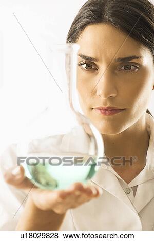 Woman holding beaker with liquid View Large Photo Image Stock Photo - Woman holding beaker with liquid. Fotosearch