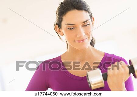 Stock Image - Woman lifting dumbbell. Fotosearch