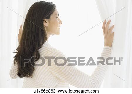 Woman looking through window View Large Photo Image Stock Image - Woman looking through window. Fotosearch