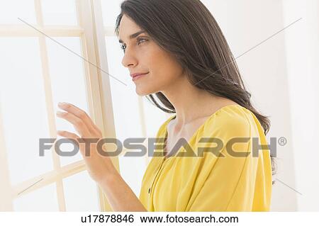Woman looking through window View Large Photo Image Stock Photograph - Woman looking through window. Fotosearch