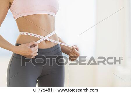 Woman measuring waist View Large Photo Image Stock Image - Woman measuring waist. Fotosearch