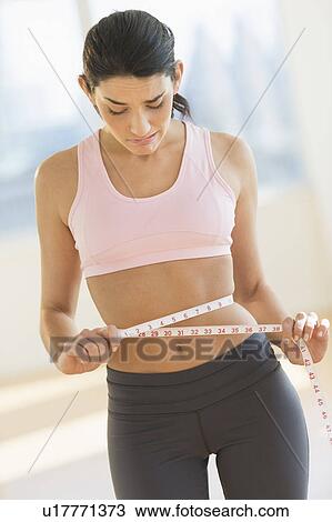Stock Image - Woman measuring waist. Fotosearch
