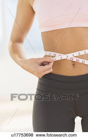Stock Photo - Woman measuring waist. Fotosearch