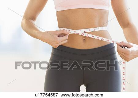 Stock Photo - Woman measuring waist. Fotosearch
