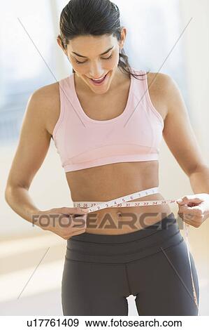 Woman measuring waist View Large Photo Image Stock Photo - Woman measuring waist. Fotosearch