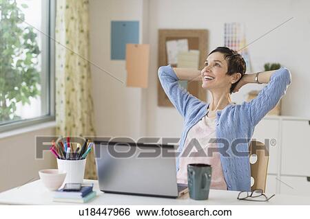 Woman relaxing in home office View Large Photo Image Stock Photograph - Woman relaxing in home office. Fotosearch