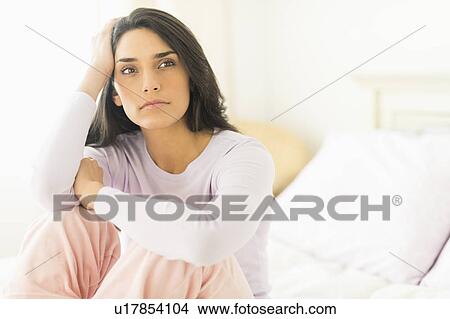 Picture - Woman sitting on bed. Fotosearch