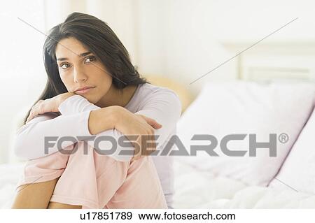 Woman sitting on bed View Large Photo Image Stock Photo - Woman sitting on bed. Fotosearch