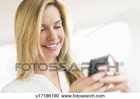 Stock Image - Woman texting on smartphone. Fotosearch