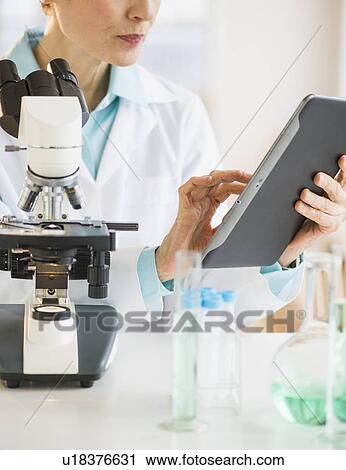 Woman using digital tablet in laboratory View Large Photo Image Stock Image - Woman using digital tablet in laboratory. Fotosearch